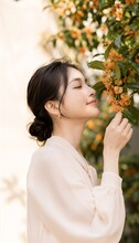 金木犀に顔を近づけて香りを楽しむ女性を描いた、実際に販売があったAI生成作品
